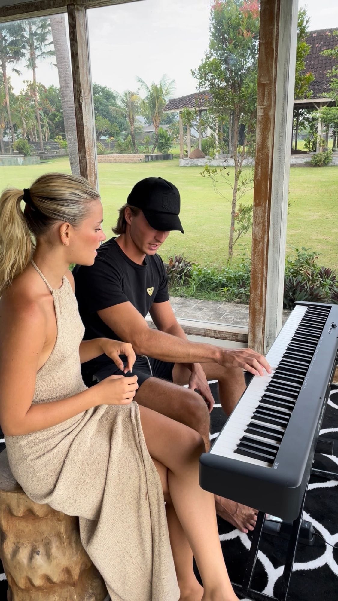 Pianofrenchy sitting beside a student at a digital piano, showing her a chord